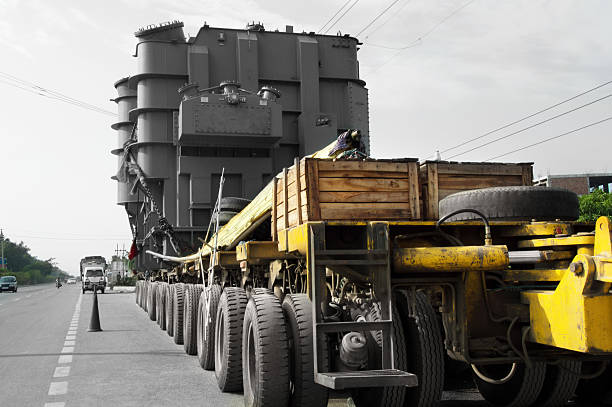 Truck Standing Near Highway Loaded with Industrial Machinery over Blue sky.