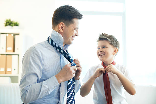 Gentlemen Photo of happy boy and his father tying neckties child tied up stock pictures, royalty-free photos & images