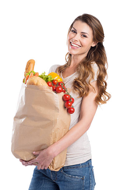 jovem mulher segurando sacola de compras - isolated isolated on white studio shot food - fotografias e filmes do acervo