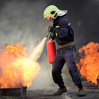 firefighter extinguishing fire with extinguisher