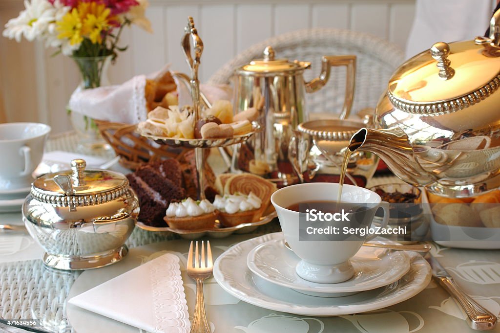 Tea being poured into a cup on a table set for afternoon tea Typical English Afternoon Tea. Afternoon Tea Stock Photo