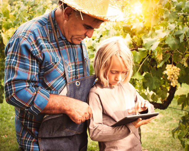 insegna al figlio di un agricoltore uomo utilizzando tablet pc - ipad farmer agronomy pc foto e immagini stock