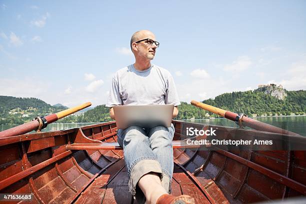 Reifer Mann Mit Laptop Im Ruderboot Stockfoto und mehr Bilder von Brille - Brille, Telearbeit, Laptop