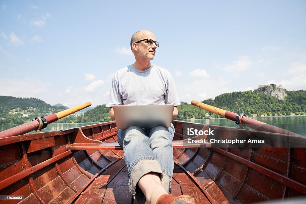 成熟した男性のラップトップを使用して手漕ぎ船 - めがねのロイヤリティフリーストックフォト