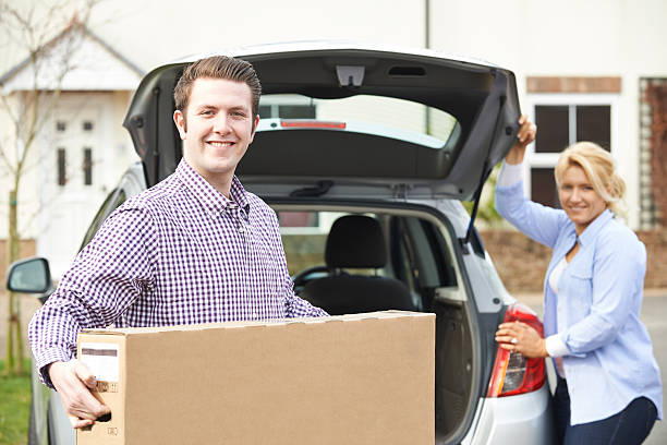 istock Couple Unloading New Television From Car Trunk 471637132
