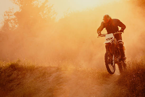 Motocross rider Motocross rider on track, strong grain added to create atmosphere. motorized vehicle riding stock pictures, royalty-free photos & images