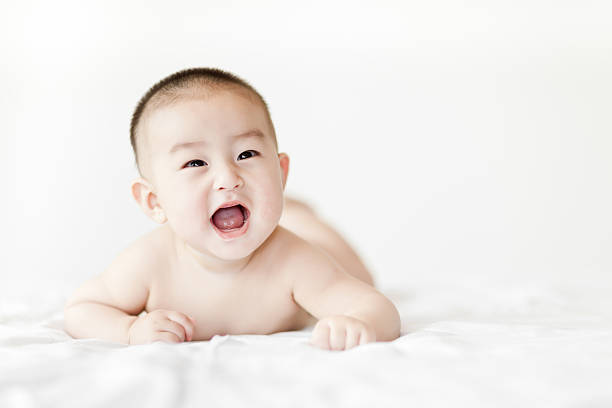 istock Naked happy little baby boy crawling on white bed 471638201