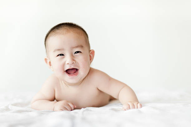 istock Naked happy little baby boy crawling on white bed 471638207