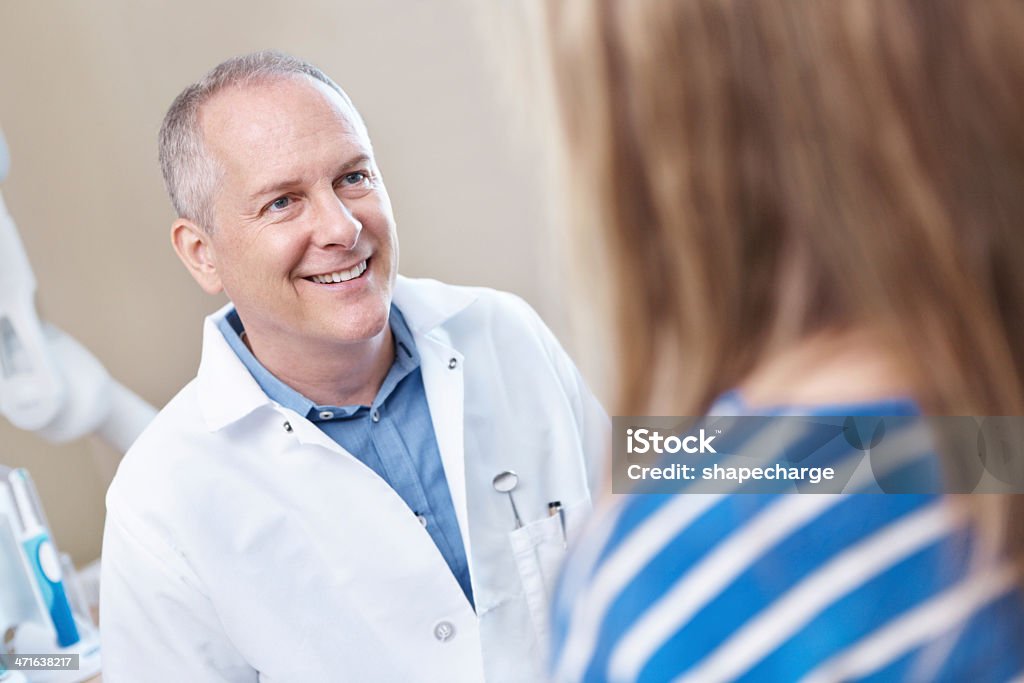 Explaining to the dentist how she chipped her tooth A mature dentist talking to a young patienthttp://195.154.178.81/DATA/istock_collage/0/shoots/784940.jpg Candid Stock Photo