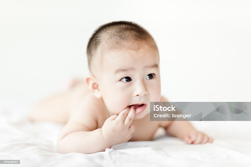 Naked gracioso Bebê Menino agachamento na cama branca - Foto de stock de 0-11 meses royalty-free