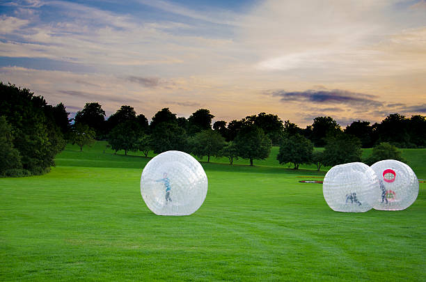 Human Hamsterballs Children rolling inside large plastic balls zorb ball stock pictures, royalty-free photos & images