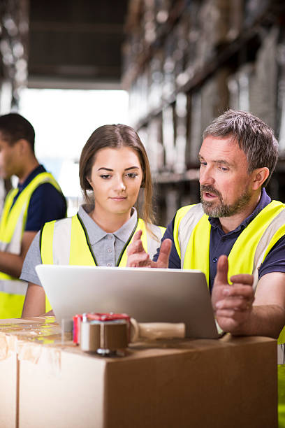 istock warehouse supervisor chats to a female colleague . 471640932