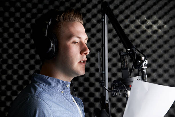 A man in a recording studio speaking into a microphone