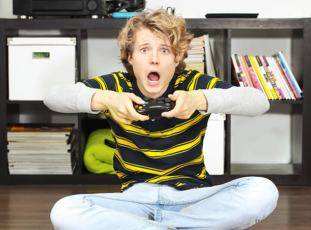 istock Shocked teenage boy  playing  game 471641325
