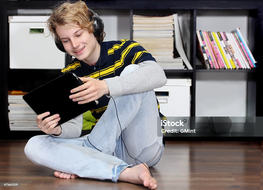 Adolescente sonriente con auriculares y tableta digital - Foto de stock de Acogedor libre de derechos