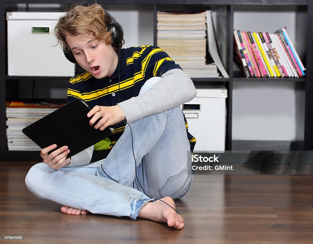 Chocado garoto adolescente com fones de ouvido, tablet digital - Foto de stock de Aconchegante royalty-free