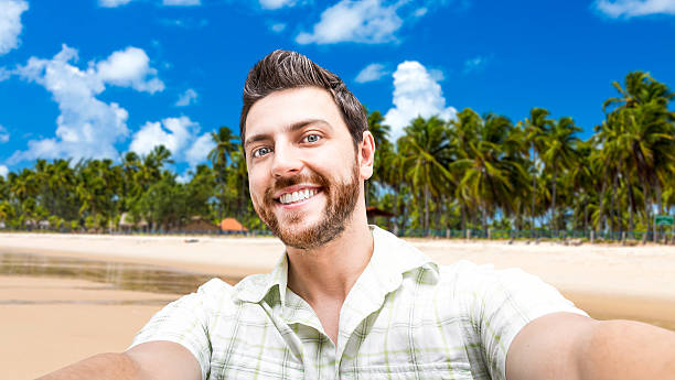 istock Happy young man taking a selfie photo on the beach 471641932