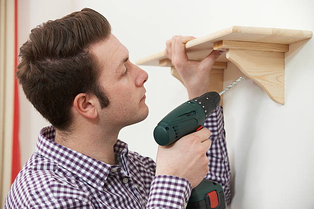 homem colocando up de prateleira de madeira em casa - shelf drill drilling installing - fotografias e filmes do acervo
