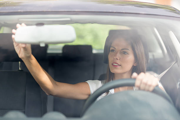 Beautiful female Driver adjusting the Rear Mirror