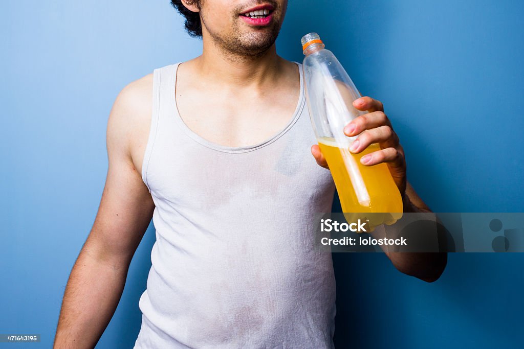 Молодой человек пить Напиток спорта после интенсивных тренировок - Стоковые фото 20-24 года роялти-фри