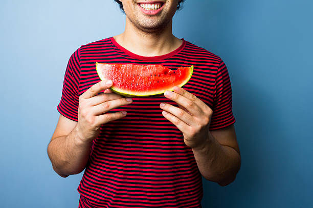 istock Young multiracial man with a slice of watermelon 471643317