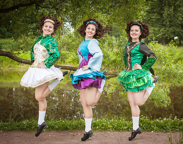 Three young beautiful girls in irish dance dress dancing stock photo