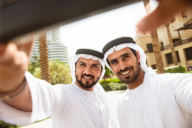 couple de sheikh amis faire un selfie sur la ville - middle eastern ethnicity sheik wealth men photos et images de collection