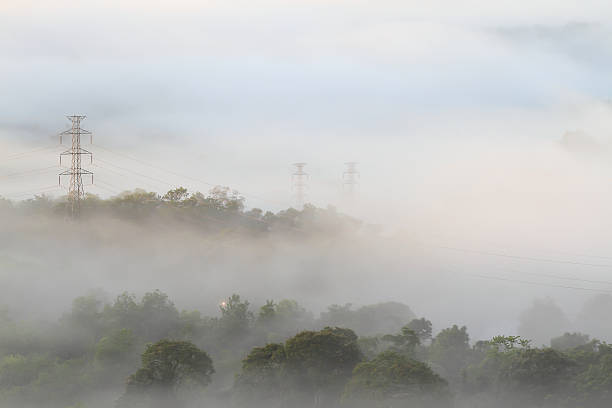 istock Electrical power lines and pylons emerging from the mist 471649951