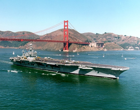 The aircraft carrier USS Abraham Lincoln sails under the Golden Gate Bridge for a port visit.
