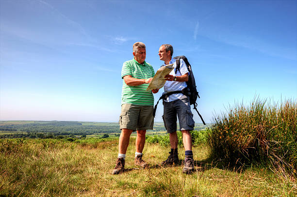 dos hombres maduros excursionismo en el campo - map uk hiking reading fotografías e imágenes de stock