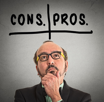 pros and cons, for and against argument concept. Thinking middle aged business man with glasses looking up isolated on grey wall background. Face expression, emotion, feeling, perception, vision