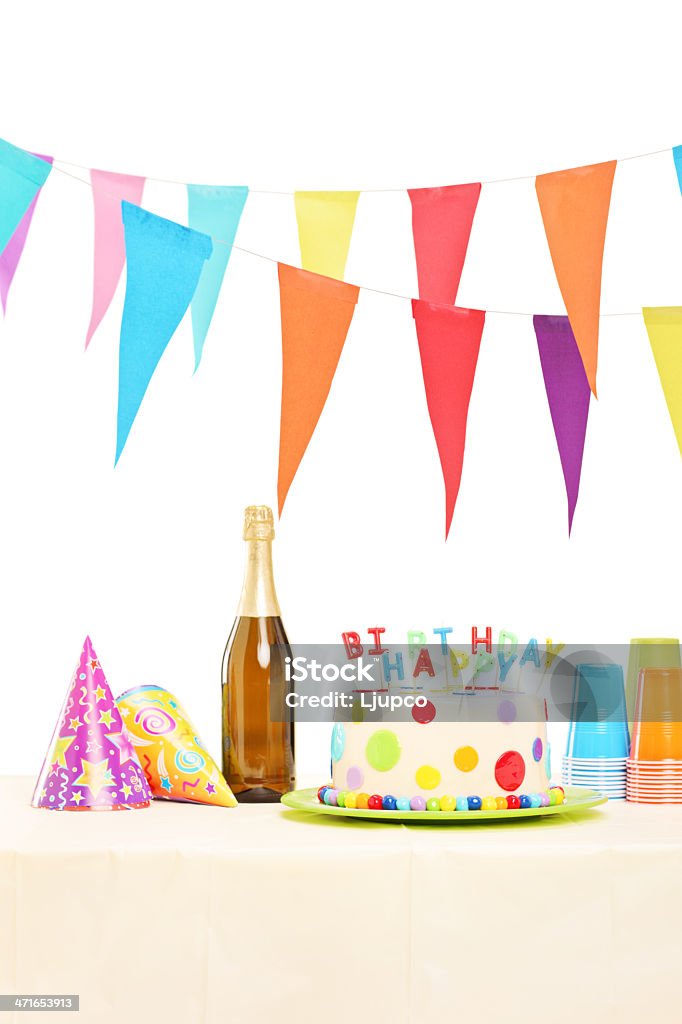 Garrafa de vinho espumante, plástico óculos, chapéus e bolo de festa - Foto de stock de Bolo de Aniversário royalty-free