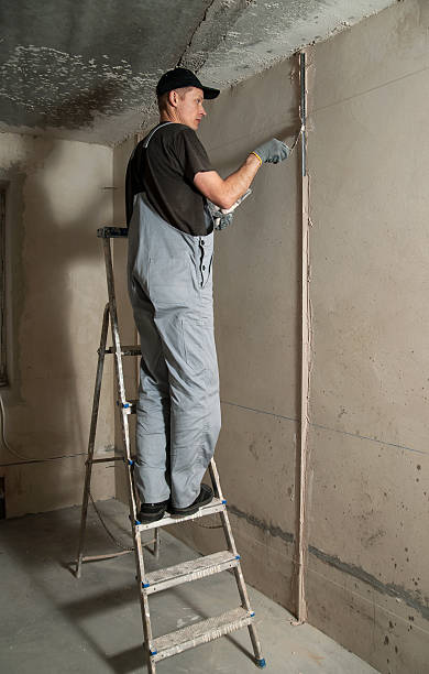 istock Woker fixes a guide to align the walls with stucco 471654360