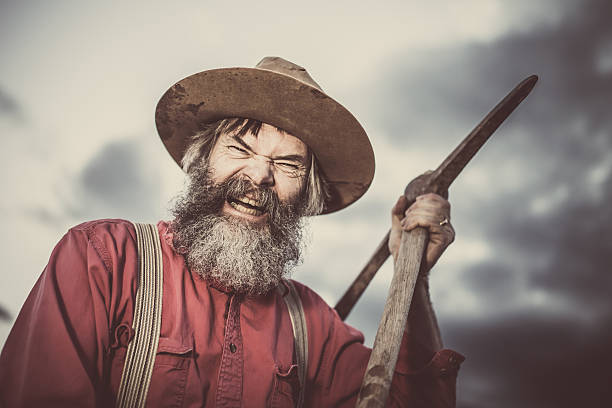 Furious Gold Miner with Pickaxe Raging Gold Miner threatening his Opponent with a Pickaxe. pick axe stock pictures, royalty-free photos & images