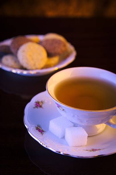 istock Old-style image cup of tea with cookies on black 471655798
