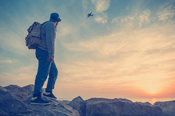 istock traveler looking at airplane at sunset 471656198