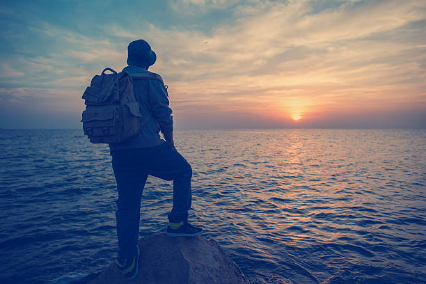 istock traveler at sunset looking far away 471656240