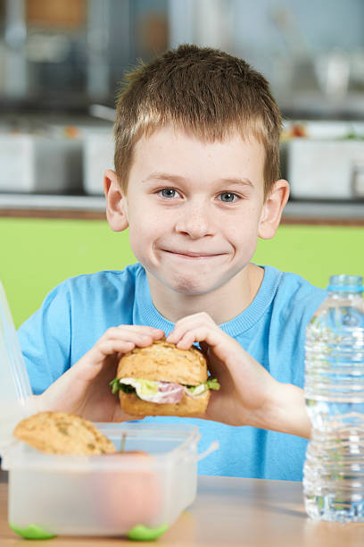 istock Male Pupil Sitting At Table In School Cafeteria Eating 471656638