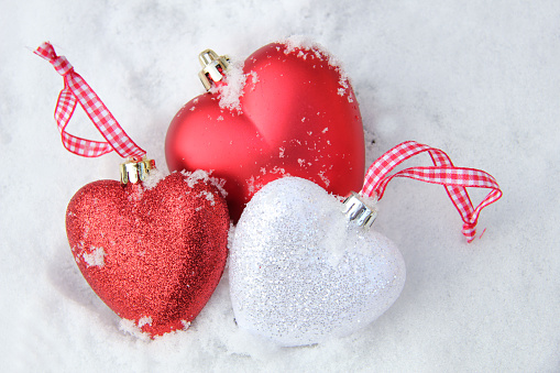 White and red heart shaped ornaments in fresh fallen snow