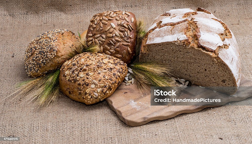 Heap of bread on cutting board Heap of bread on cutting board on textile background Backgrounds Stock Photo