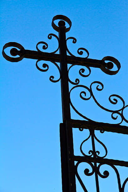 iron fence with Detail of a wrought iron fence with a cross geochelone yniphora stock pictures, royalty-free photos & images