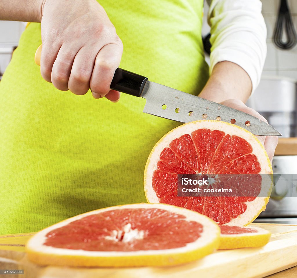 Kobiecej ręce cięcia grapefruit - Zbiór zdjęć royalty-free (Bar szybkiej obsługi)