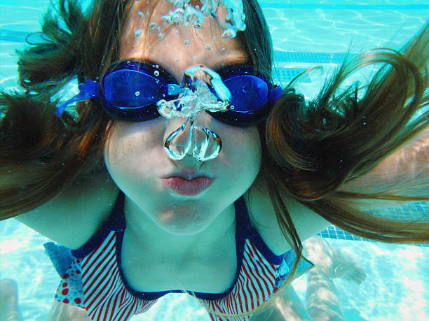 beautiful swimmer woman portrait with red swimming cap and swimming googles.