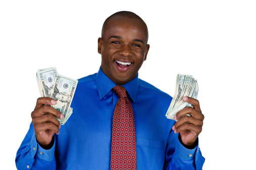 Man wearing a suit and holding money with an excited expression 