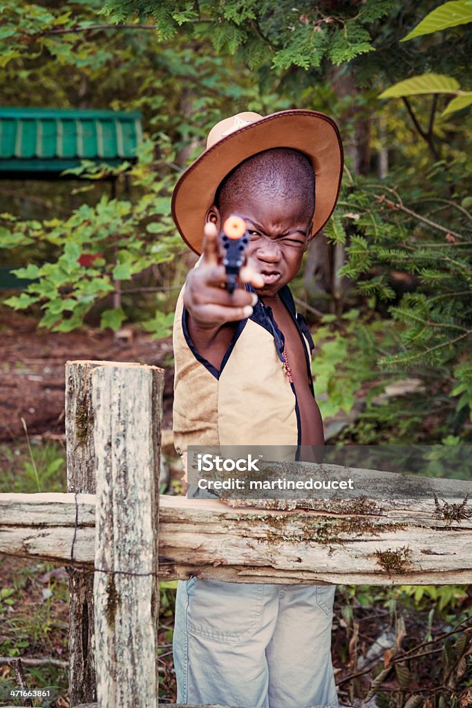 Little black Cow-boy garçons jouant avec un pistolet en plastique. - Photo de 4-5 ans libre de droits