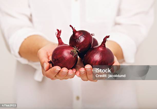 Mujer Mostrando Cebollas Rojas Foto de stock y más banco de imágenes de Cebolla - Cebolla, Foto de estudio, Mujeres