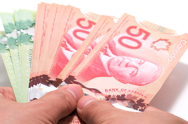 istock Hand holding a series of Canadian banknotes 471664653