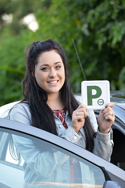 istock Young Australian female teenager learner driver holding a P plate 471665516