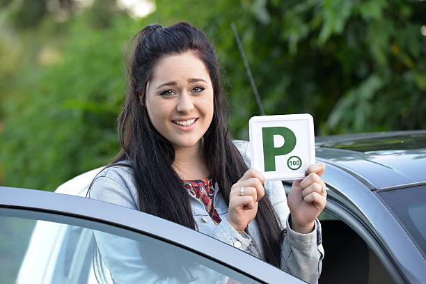 istock Young Australian female teenager learner driver holding a P plate 471665522