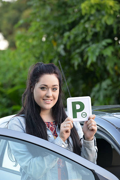 istock Young Australian female teenager learner driver holding a P plate 471665524